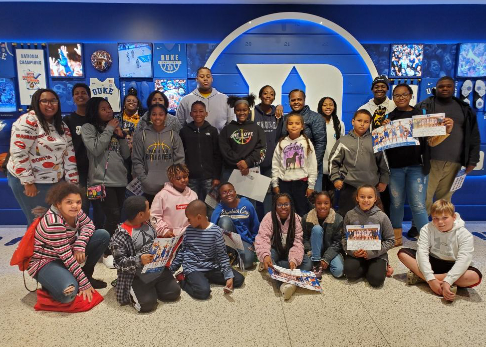 A large group of children attend the Duke vs. Georgia Tech basketball game with their chaperones.