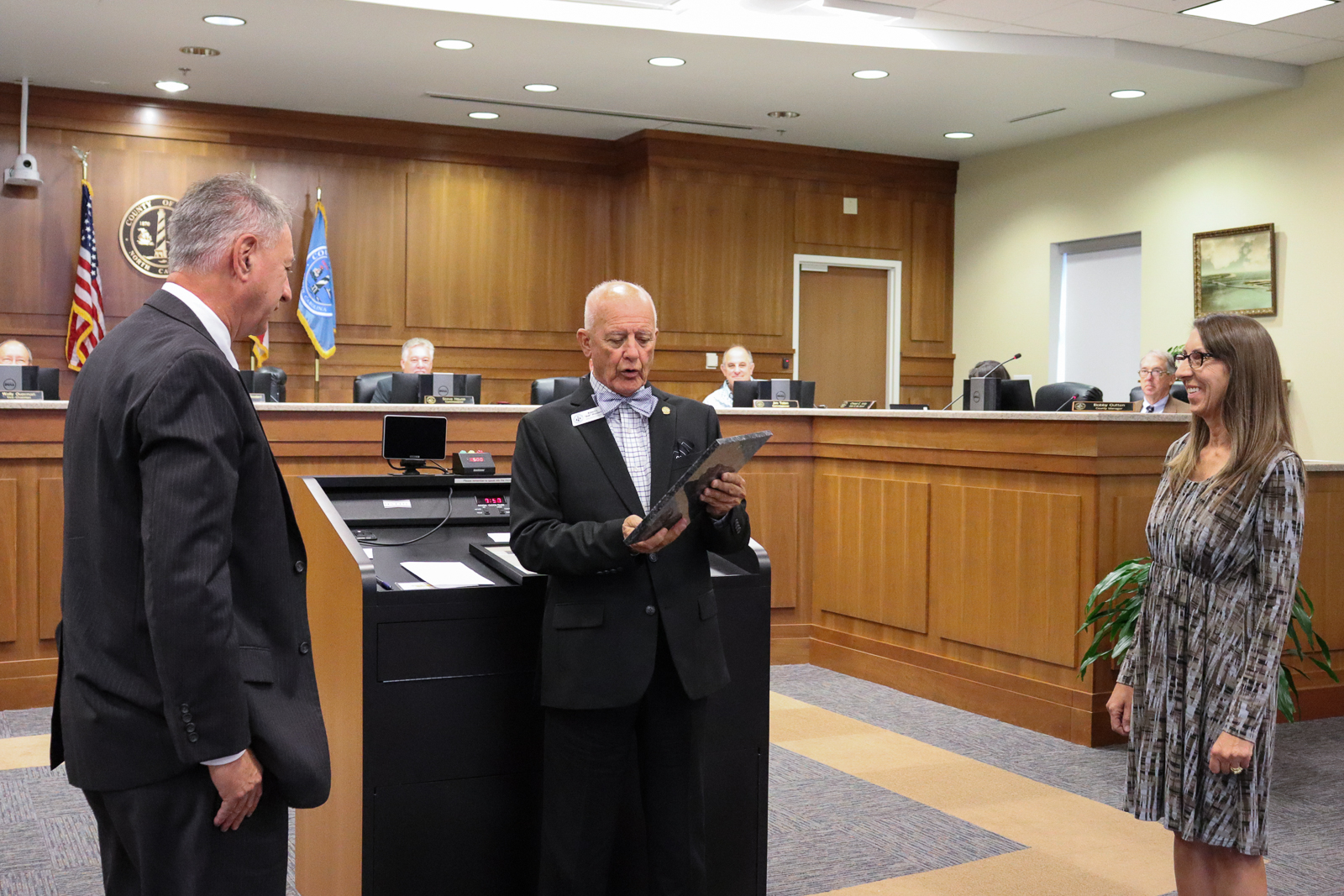 Dare County Board of Commissioners Chairman Bob Woodard presents the award to Finance Director David Clawson and Assistant Finance Director Sally DeFosse.