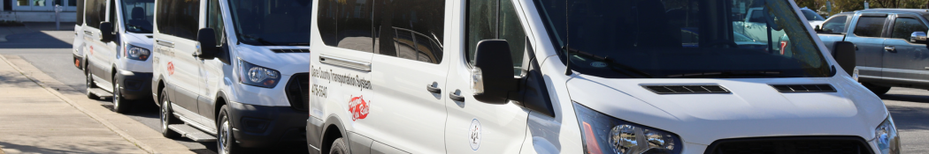 Image of three Dare County Transportation System vans parked in a row.