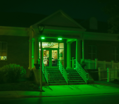 Image of the Virginia Tillett Community Center lit in green light.