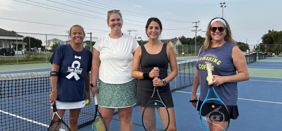 Four OBXTA women's league players stand together on a tennis court.