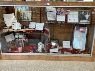 Manteo November Display Case - Veterans Advisory Council - pictured are Letters and Photos of Veterans and American flags