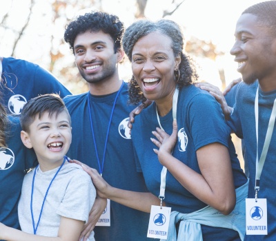 Image of a group of volunteers standing together smiling and laughing.